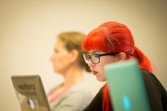 图为英国波胆网站的一名女学生在讲课时在笔记本电脑上写字.
