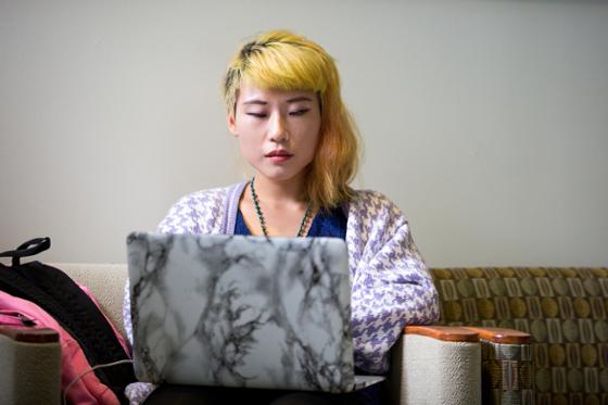 图为波胆网站的一名女学生正在用笔记本电脑工作