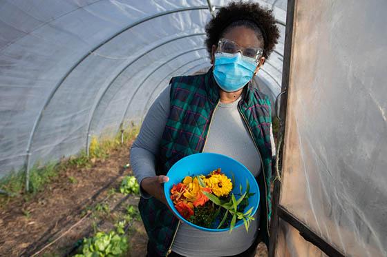 波胆网站学生戴面具的照片, 在温室门口捧着一碗收获的农产品